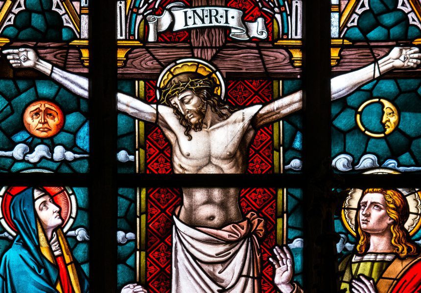 A stained glass window of jesus on the cross.