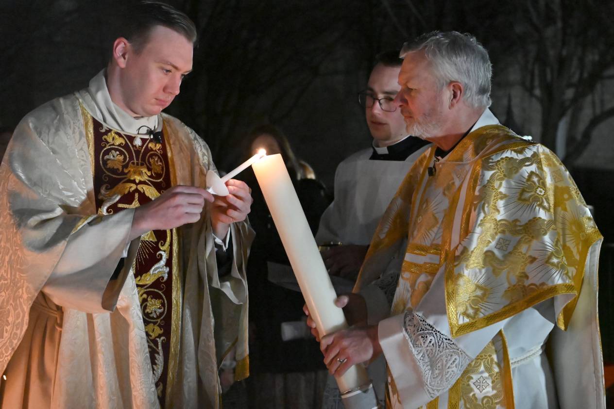 A priest lighting the candle for an altar.