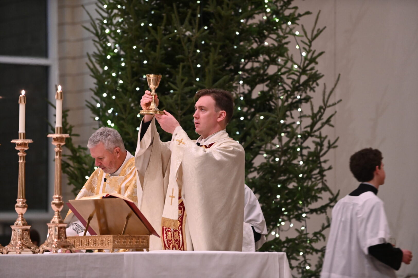 Priest raising the chalice of the precious blood.